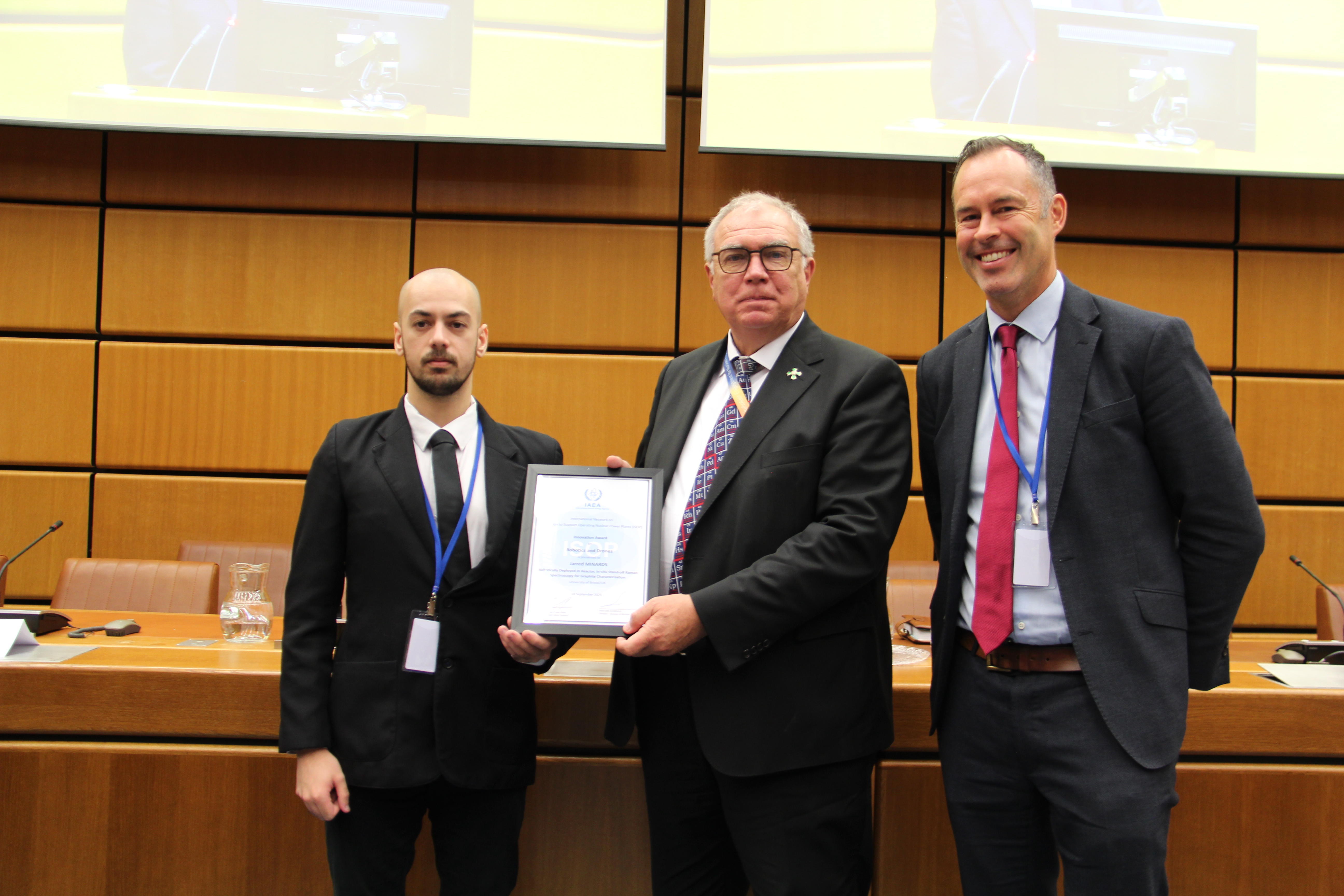 Jarred Minards and Tom Scott are being presented a certificate